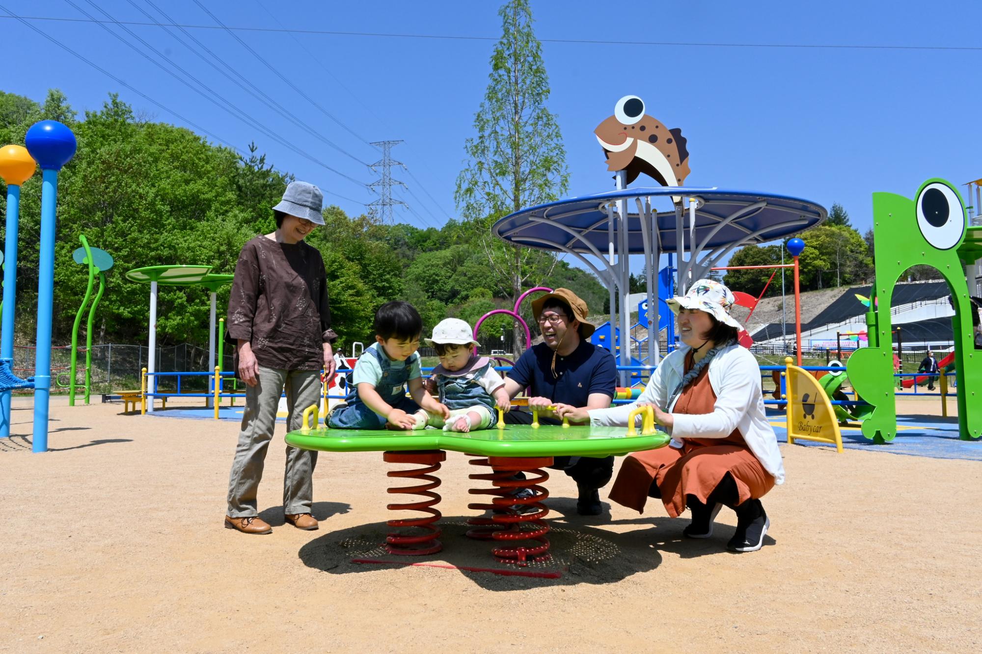 乳幼児用の遊具で遊ぶ3世代ファミリー