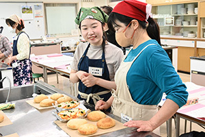 焼きあがったパンを見てほほ笑む生徒