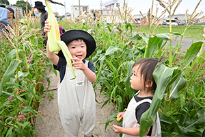 皮を剥いてトウモロコシの実を見せてくれる男の子