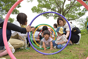 フープのトンネルをくぐるこどもたち