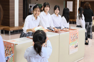受け付けでパンフレットを配る松陽高校の生徒
