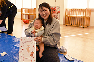 くまの足型アートを掲げる保護者