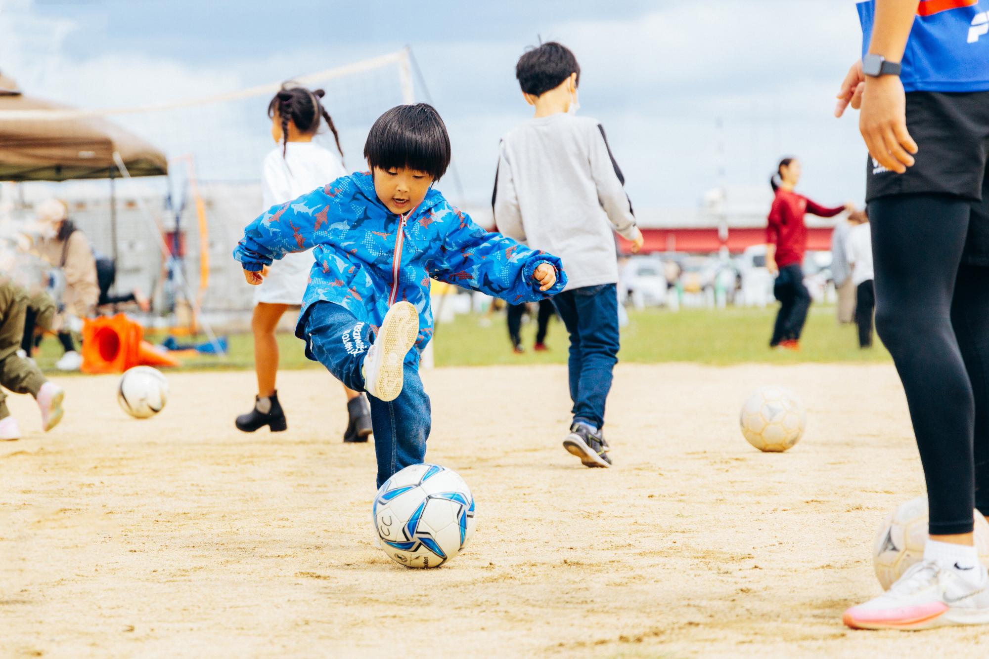 サッカーボールを蹴る少年