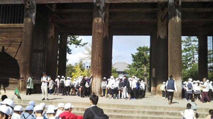 大きな門の下をくぐり抜ける児童たちの写真