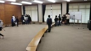 ホワイトボードのある室内に児童たちが立っている写真