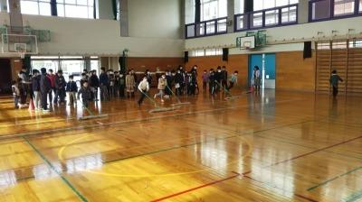 体育館内でモップがけをする児童たちの写真