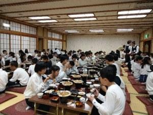 テーブルに並んで集まり、食事をとる児童たちの写真