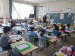 児童達が教室で着席し先生の話を聞いている様子の写真