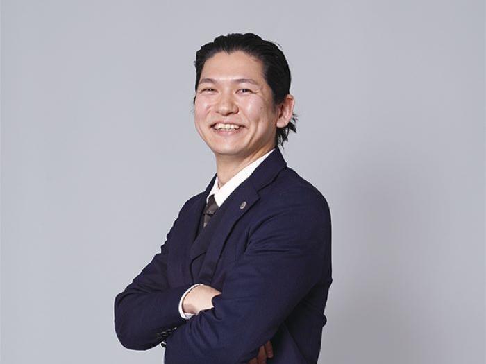 「子どもの明るい未来を」というパンフレットを持つこども部家庭支援課の石井さんの写真