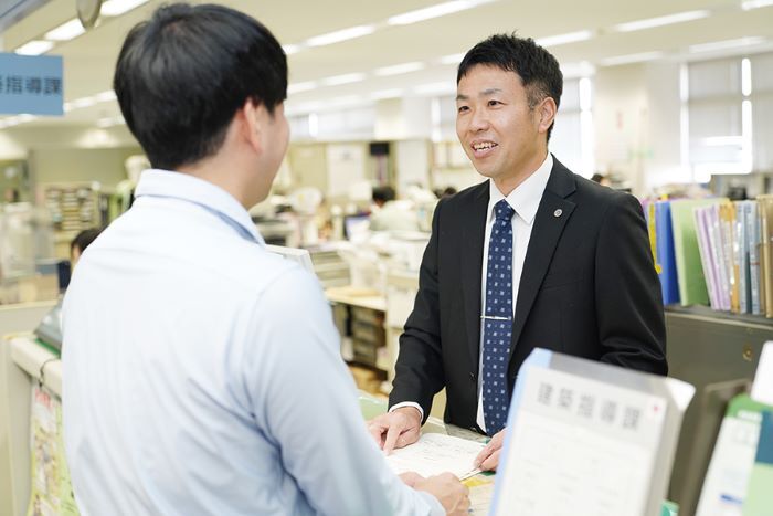 窓口対応をする建設部建築指導課の山田さん