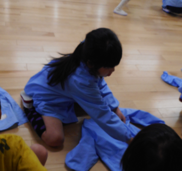 脱いだ服をたたんでいる園児の写真