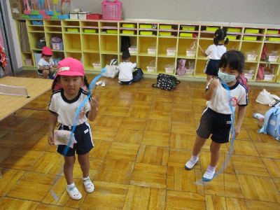 オリンピックごっこでリボンをする園児