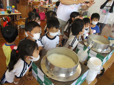 炊き上がったご飯の釜をのぞく園児