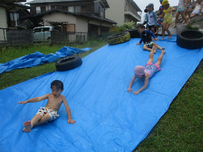 築山ウォータースライダーを楽しむ年中児