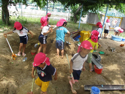 砂場で大きな山を作る年中児