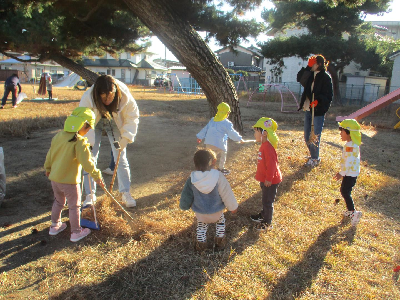 落ち葉を拾う園児と保護者