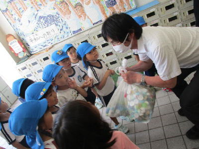 小学校の校長先生に集めたエコキャップを渡す年長児