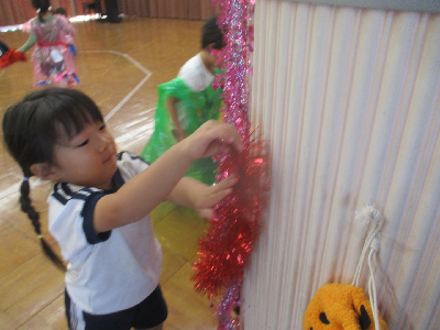 ハロウィンパーティーの飾りつけをする園児
