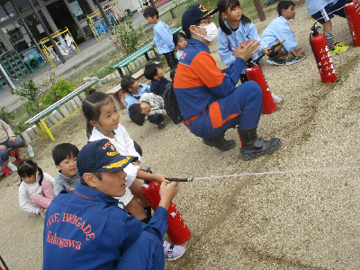 消火器体験をする園児