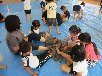 足で粘土を触る園児