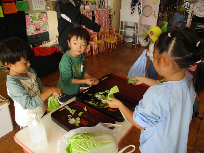豚汁の白菜をちぎる年少児