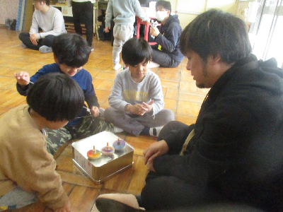 お父さんと一緒にコマ回しをする年中児