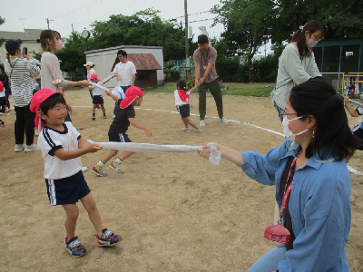 タオルでふれあい遊びをする親子