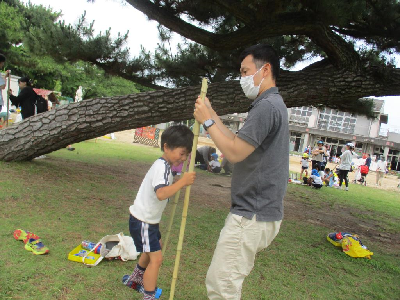 作った竹馬に乗る年長児
