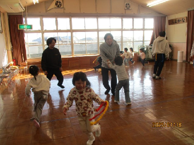 お父さんとしっぽとりをする園児
