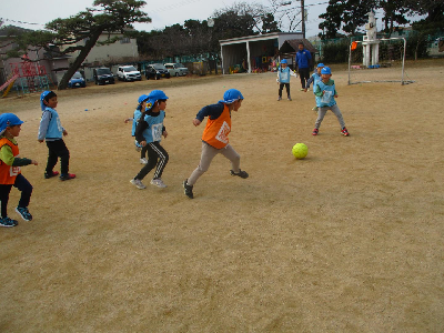 サッカーをする園児