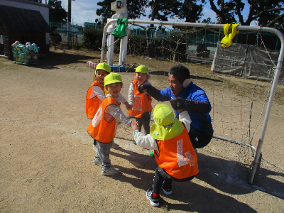 チームでサッカーをする園児