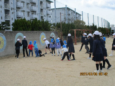 小学生と校庭で遊ぶ年長児