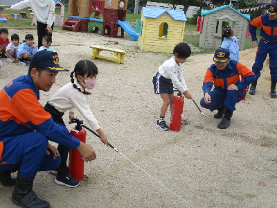 消火器体験をする園児