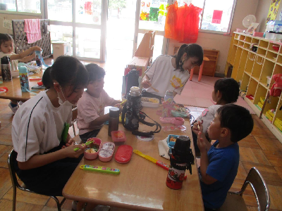 中学生と一緒にお弁当を食べる年中児