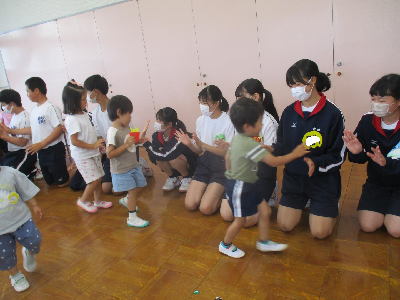 中学生とハイタッチをする園児