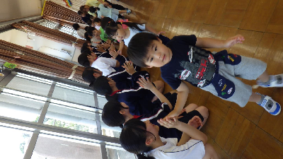 中学生とバイバイをする園児
