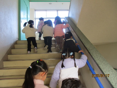 階段で高い場所まで避難する園児