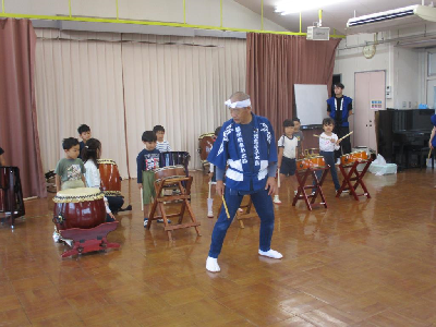 和太鼓のたたきかたを教えてもらう園児