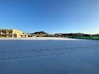 うっすら雪が一面に積もっている運動場の様子