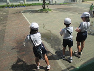水でっぽうの様子。地面に、とばした水のあとがついている。