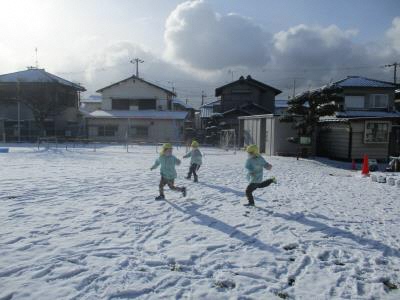 雪の中を走る幼児