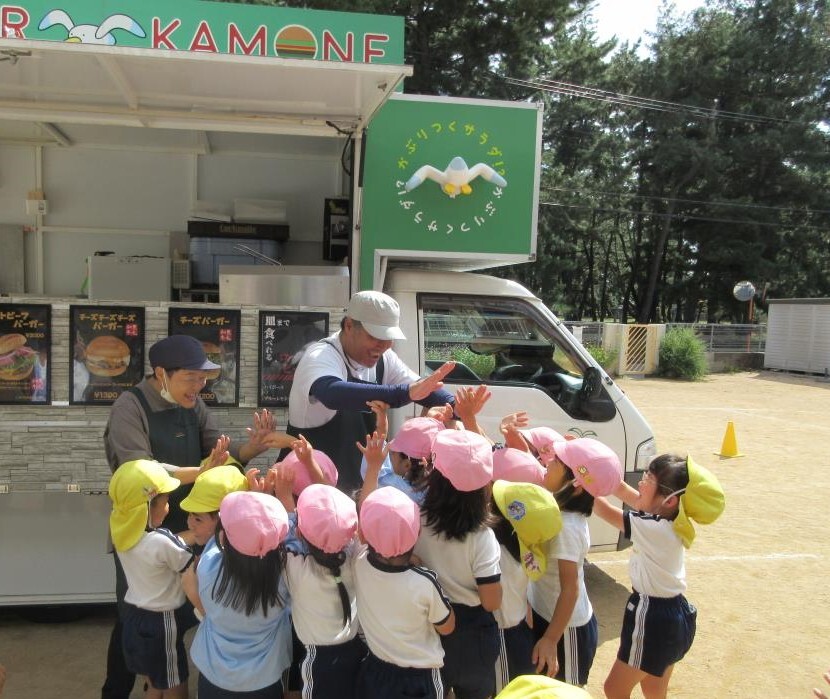 カモネバーガーさんのキッチンカーが園庭にきて、子ども達が大喜びしている様子。