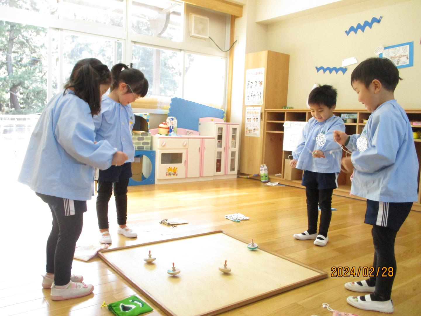 コマ回し大会で、自分のコマが回るのを見ながら、応援している様子。
