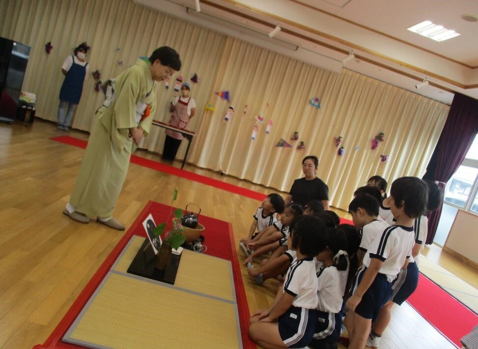 お茶席で季節の花を先生から紹介していただいているところ
