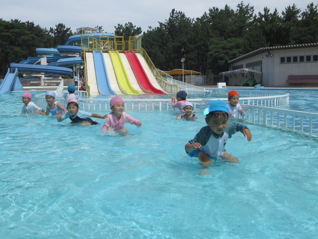プールの水に肩までつけながら、友達と遊んでいる様子。