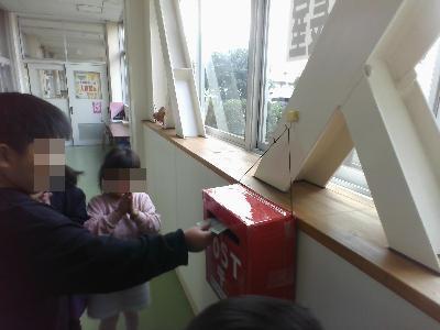 書いた手紙をポストに入れるこども達