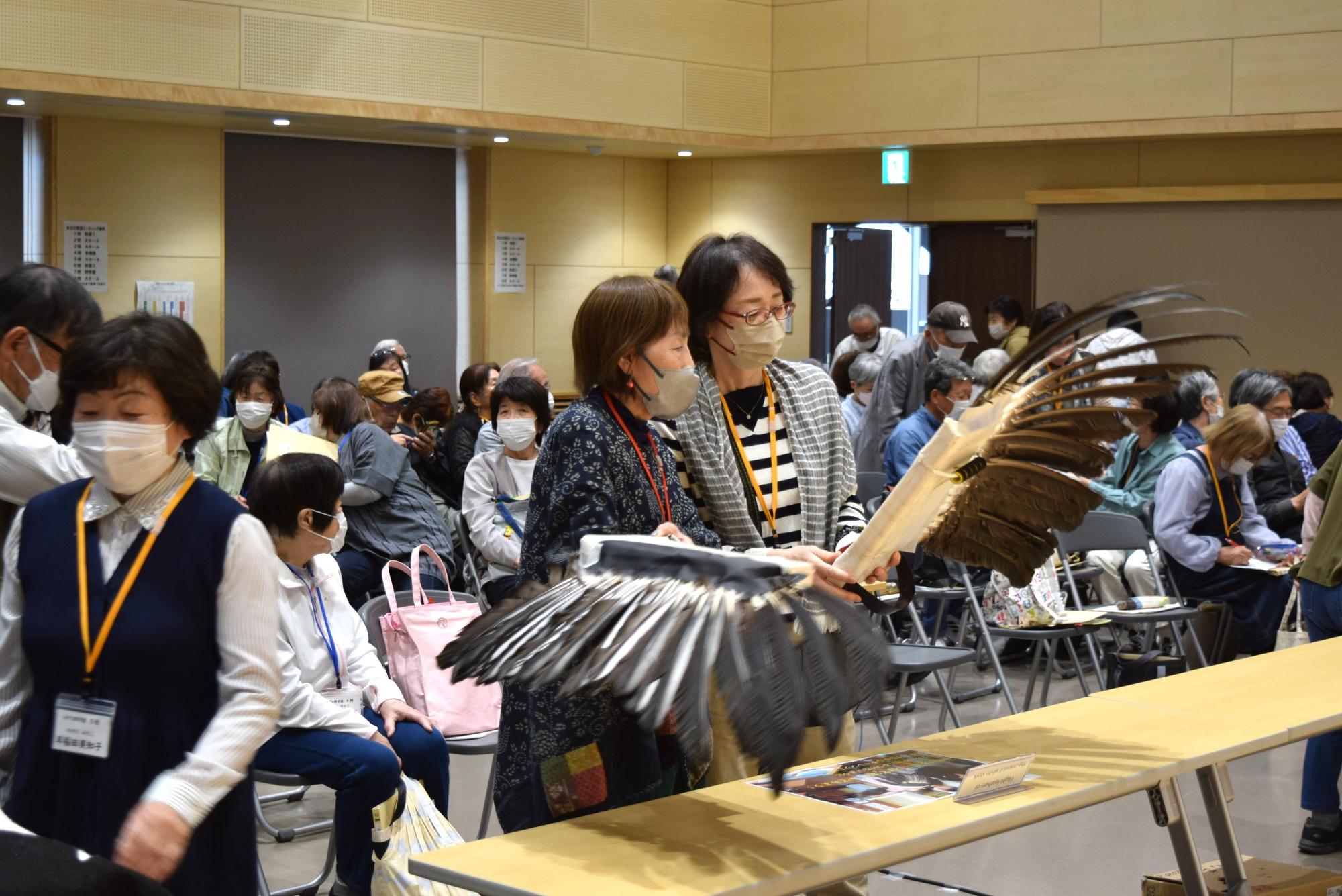 コウノトリの羽を観察する学園生