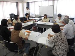 窓側にホワイトボードがある部屋の箇所で意見交換をしているB型事業所職員達と専門部会員達の写真