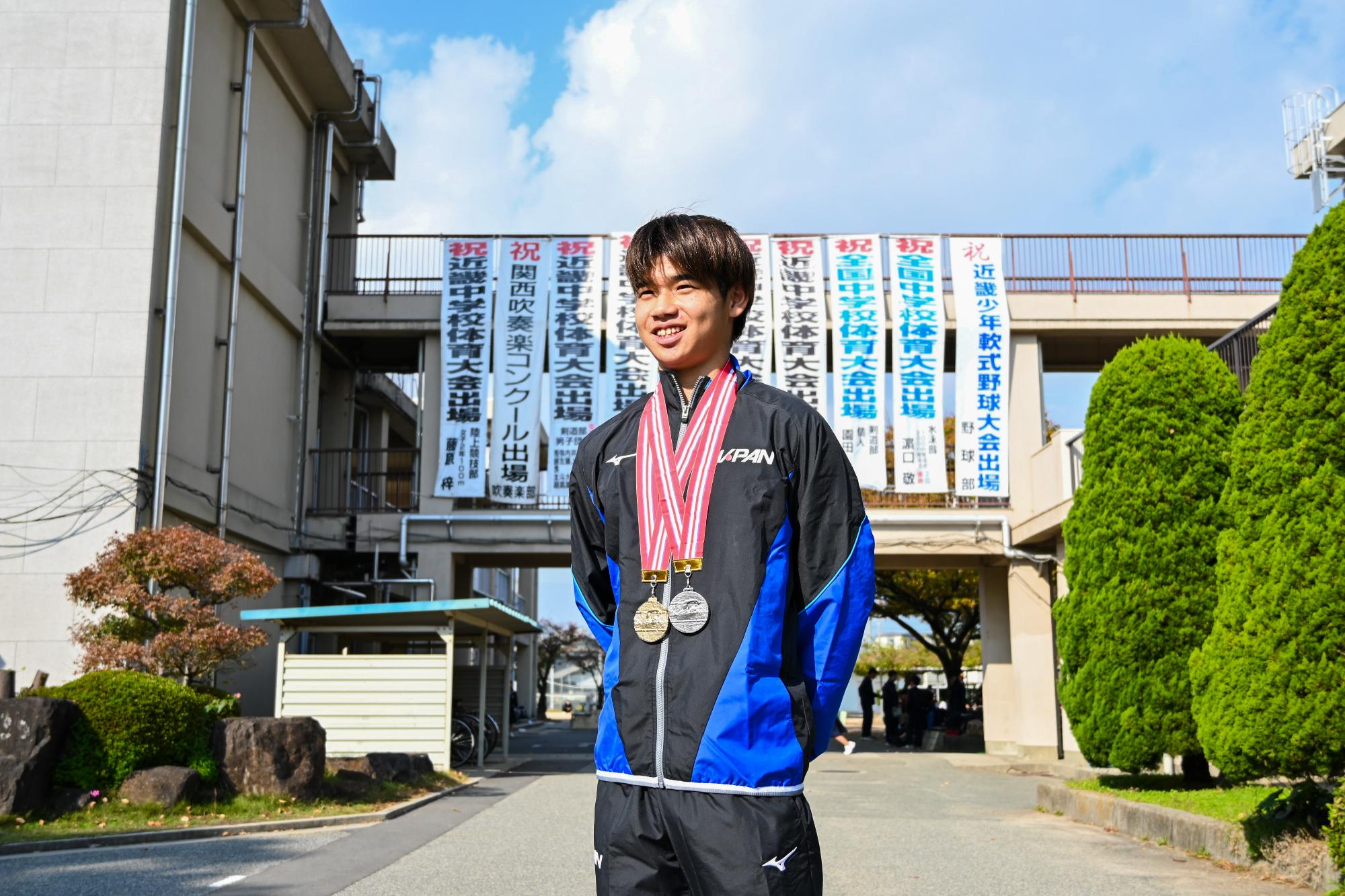 加古川中学校の校舎前で笑顔を見せる濱口さん