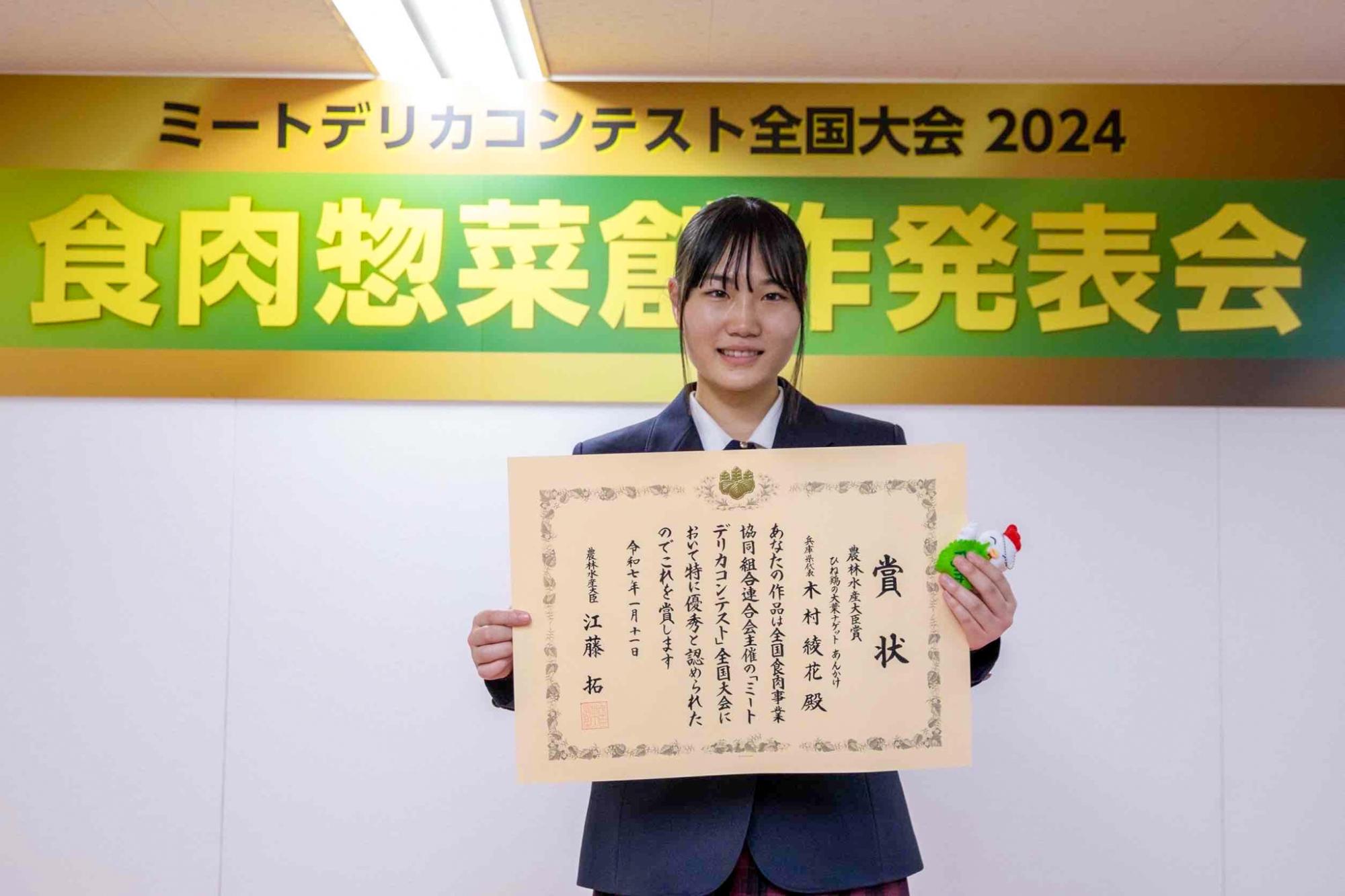 ミートデリカコンテスト受賞式で賞状を持つ木村さん